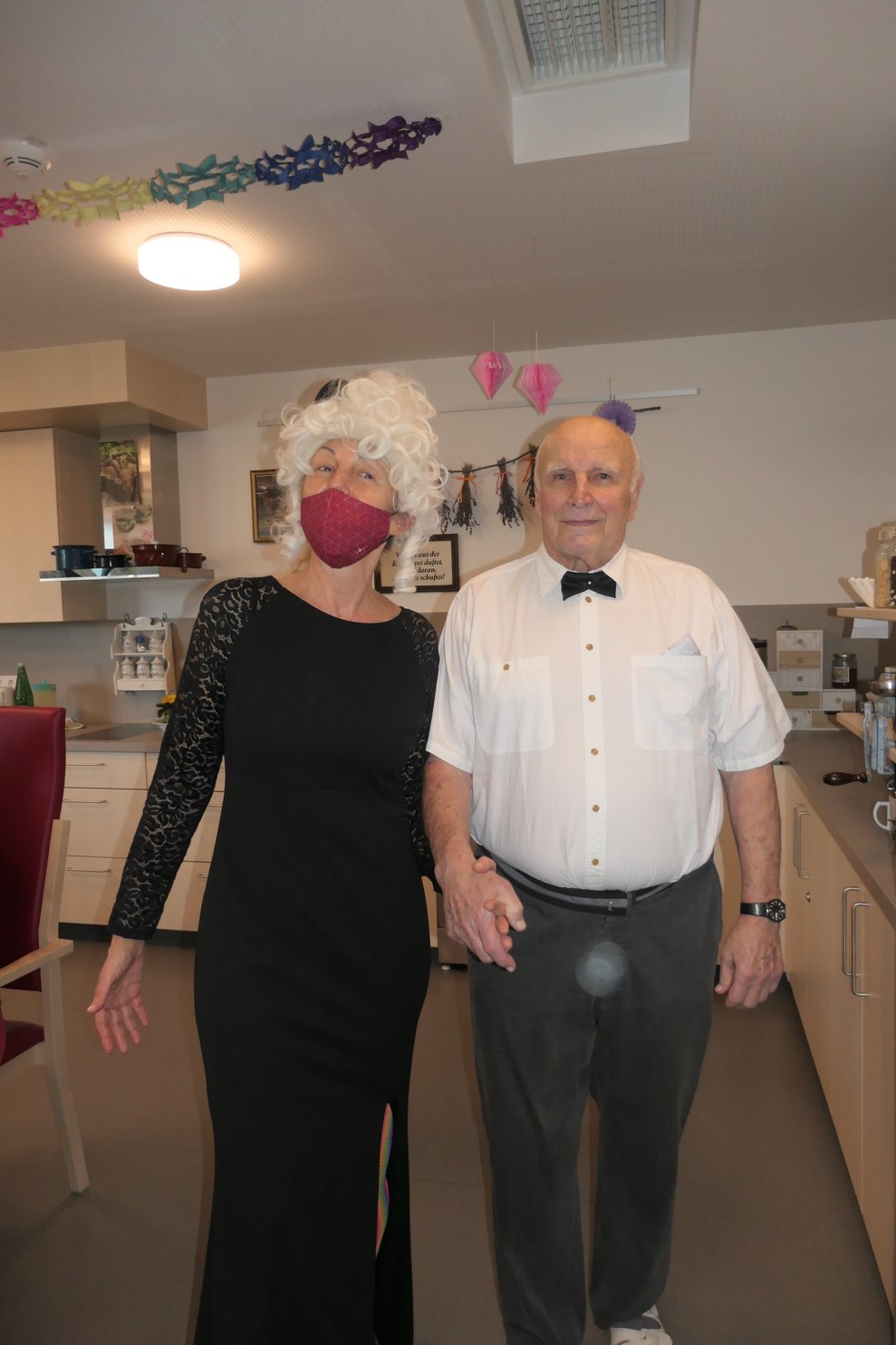 Eine Dame im Ballkleid und ein Herr mit Anzug.