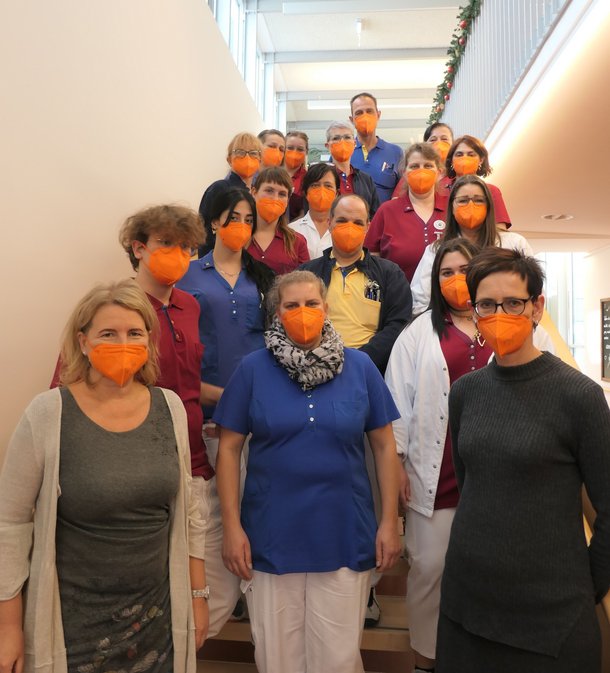 „Orange the World – 16 Tage gegen Gewalt“ Eingige MitarbeiterInnen posieren mit der orangen Maske.