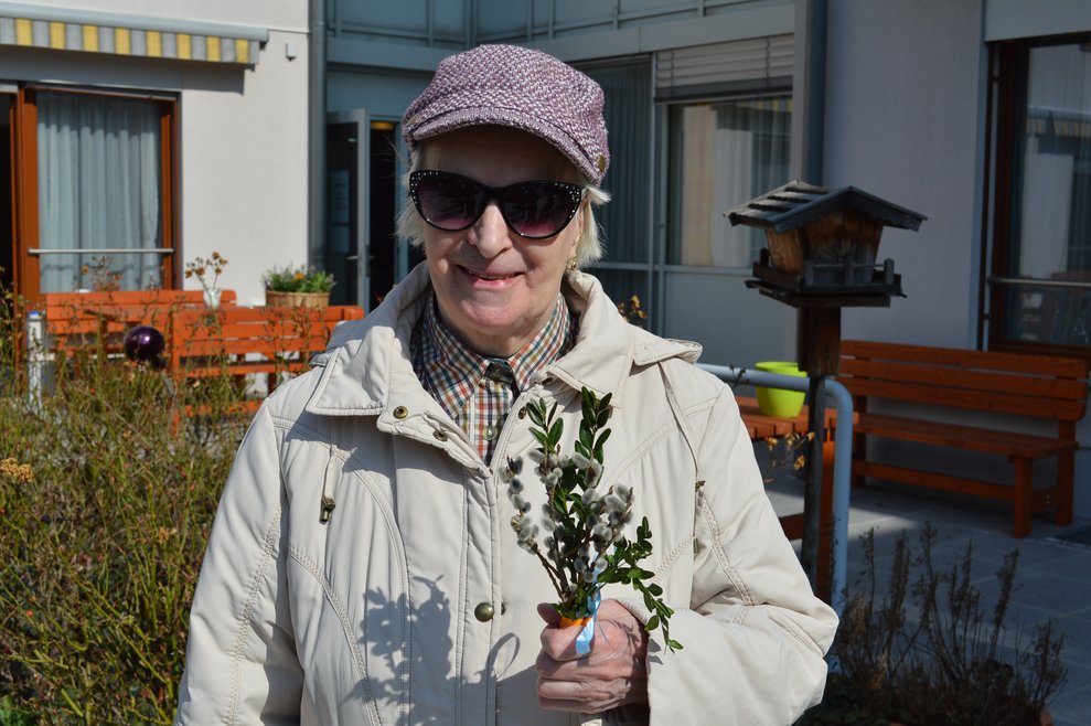 Eine Frau hält einen Palmbuschen.