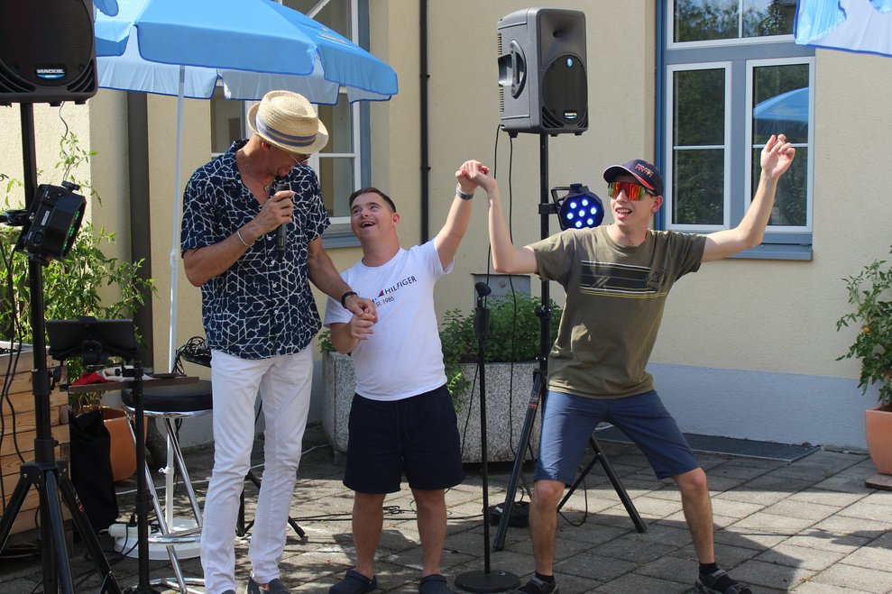 Zwei Personen tanzen mit dem Sänger.