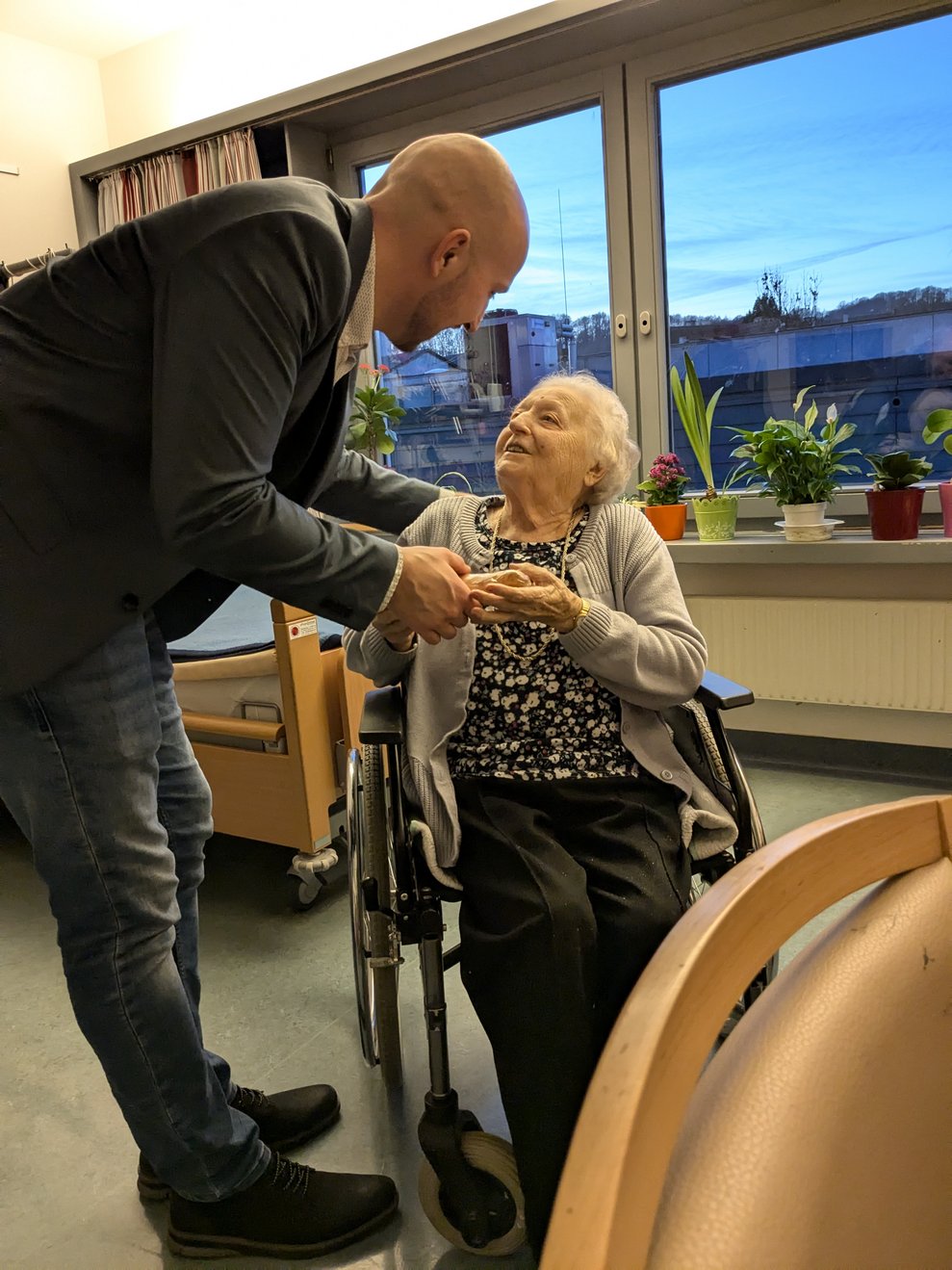 Herr Bürgermeister überreicht einer Dame das Geschenk.