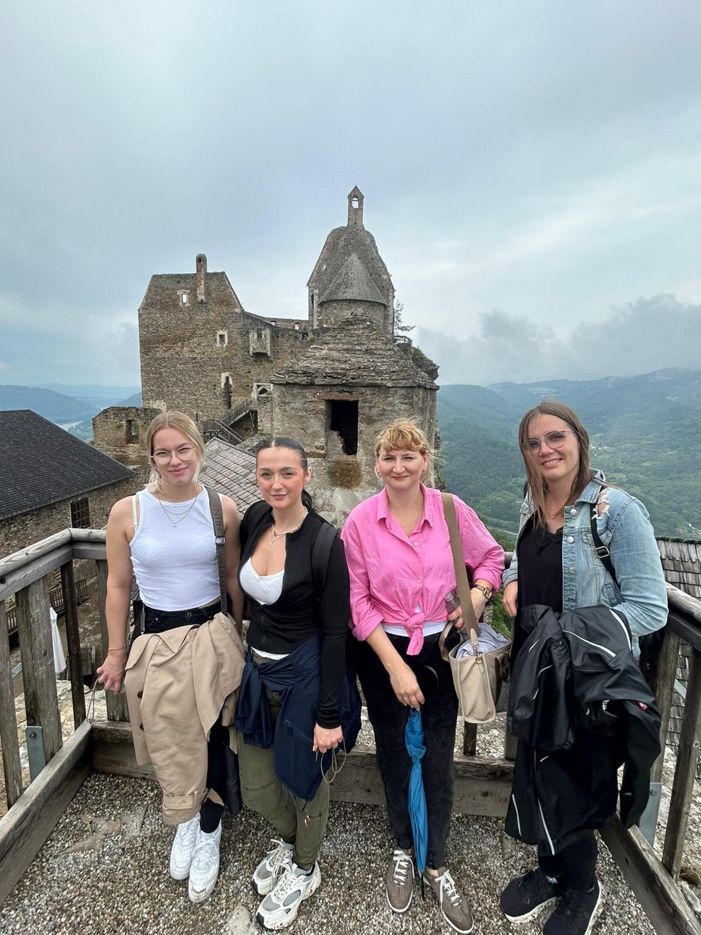 Vier Frauen und im Hintergrund die Burg
