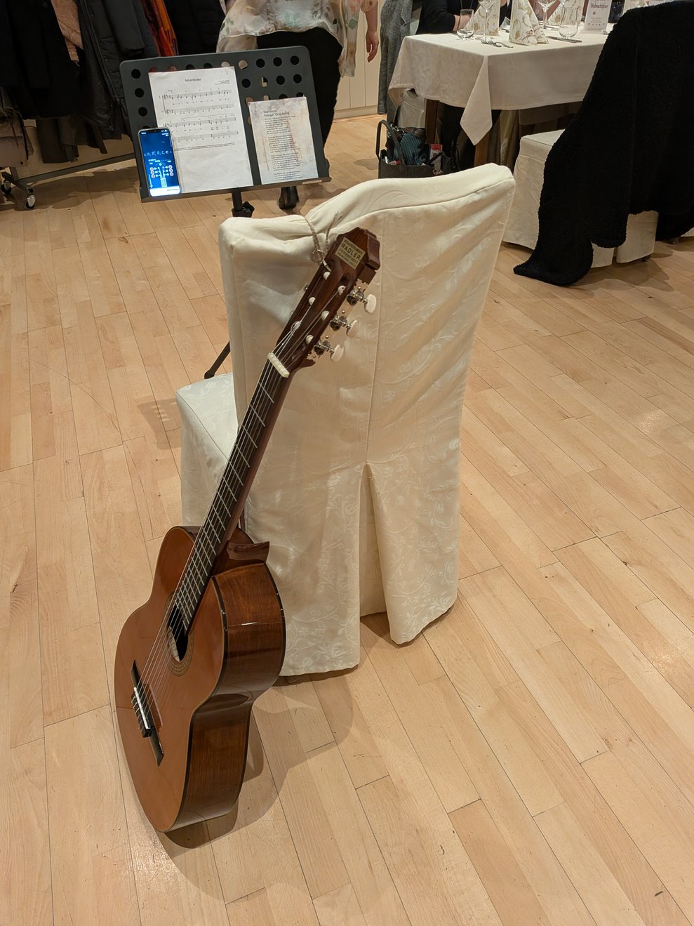 Die Gitarre lehnt vor einem Stuhl mit Husse.