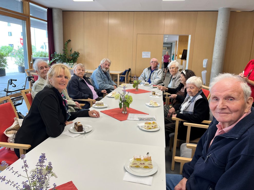Gruppe sitzt bei schön gedecktem Tisch