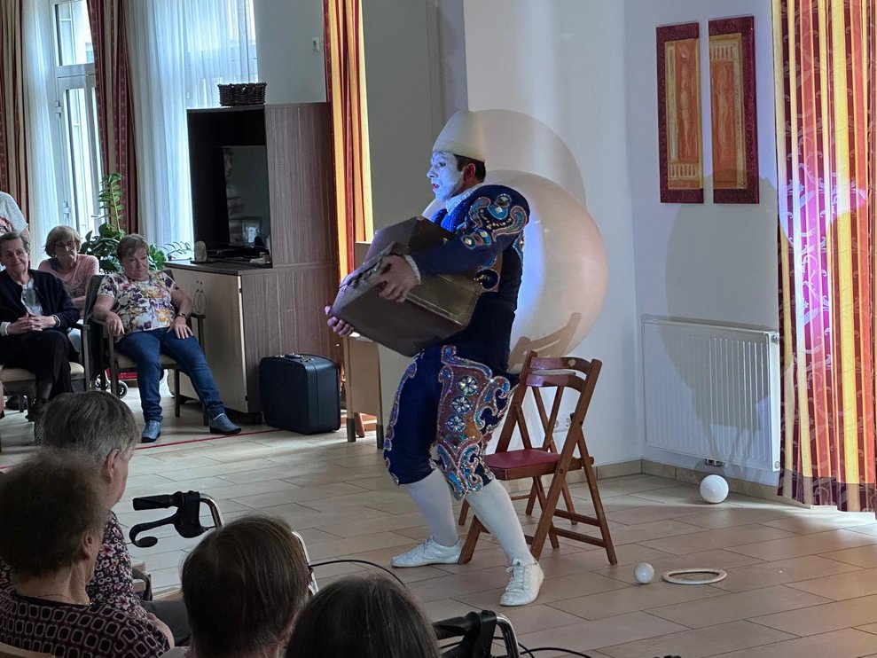 ein Clown bei seiner Vorstellung mit einem großen Koffer