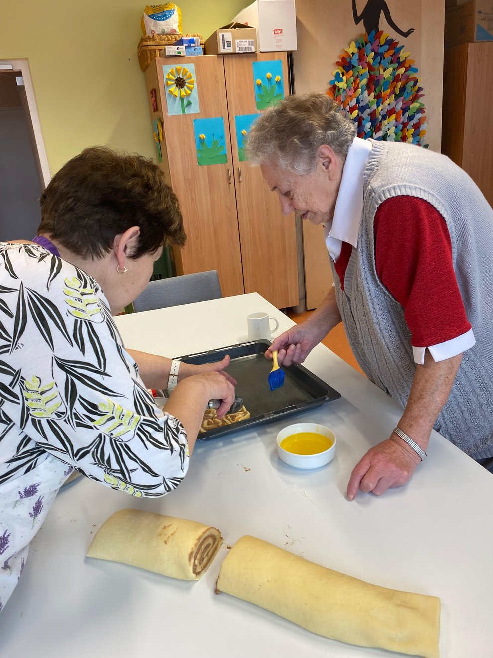 Bewohnerin legt die Zimtschnecken aufs Backblech 