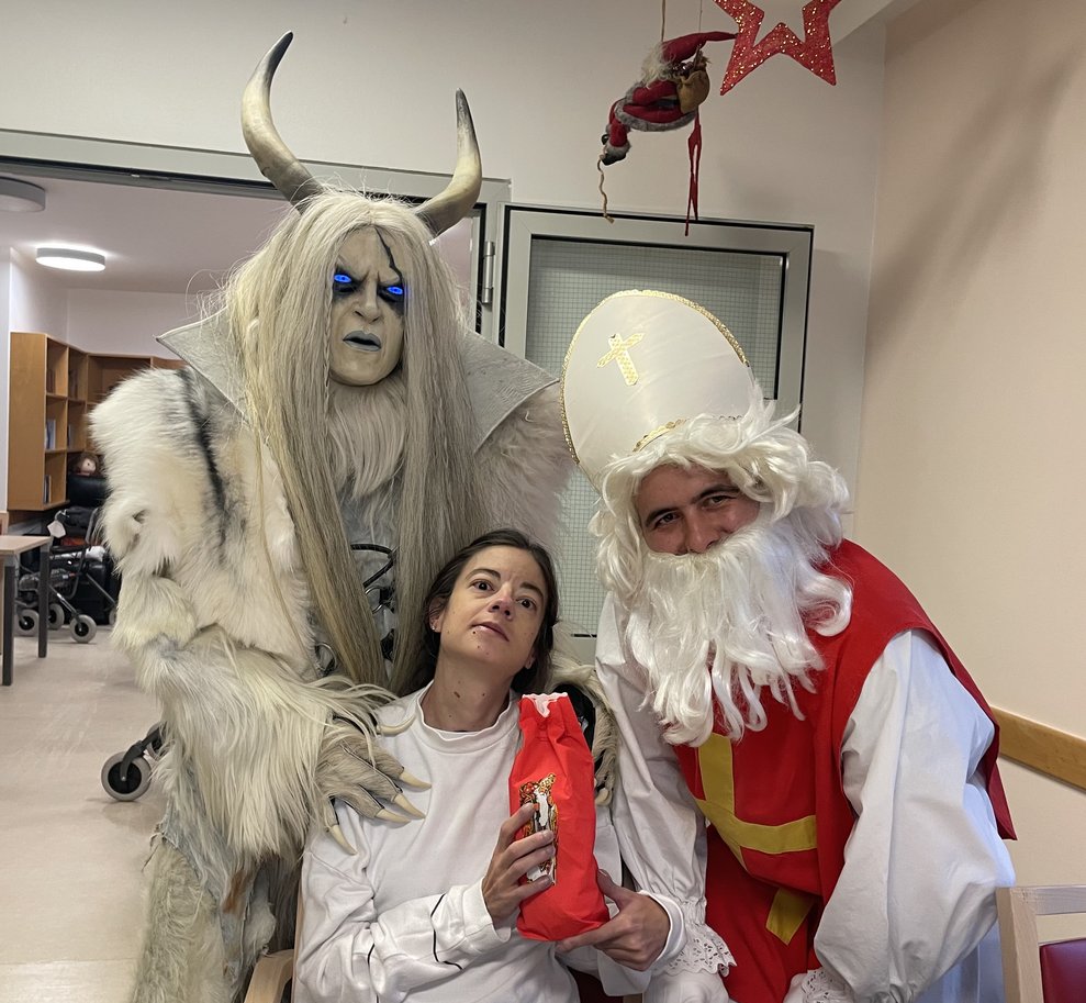 Eine Frau mit Nikolo und Krampus.