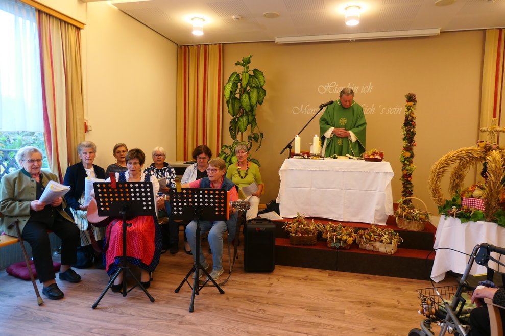 Der Pfarrer hält die Messe, links davon die Bäuerinnensinggruppe.