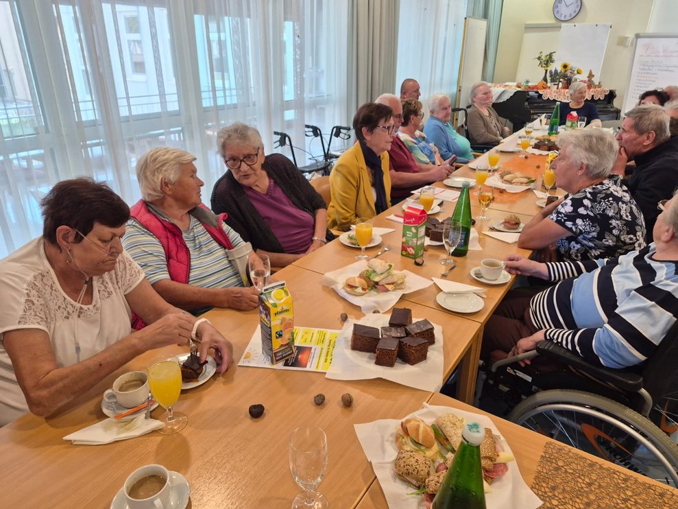 Sitzende Personen beim Kuchen essen.