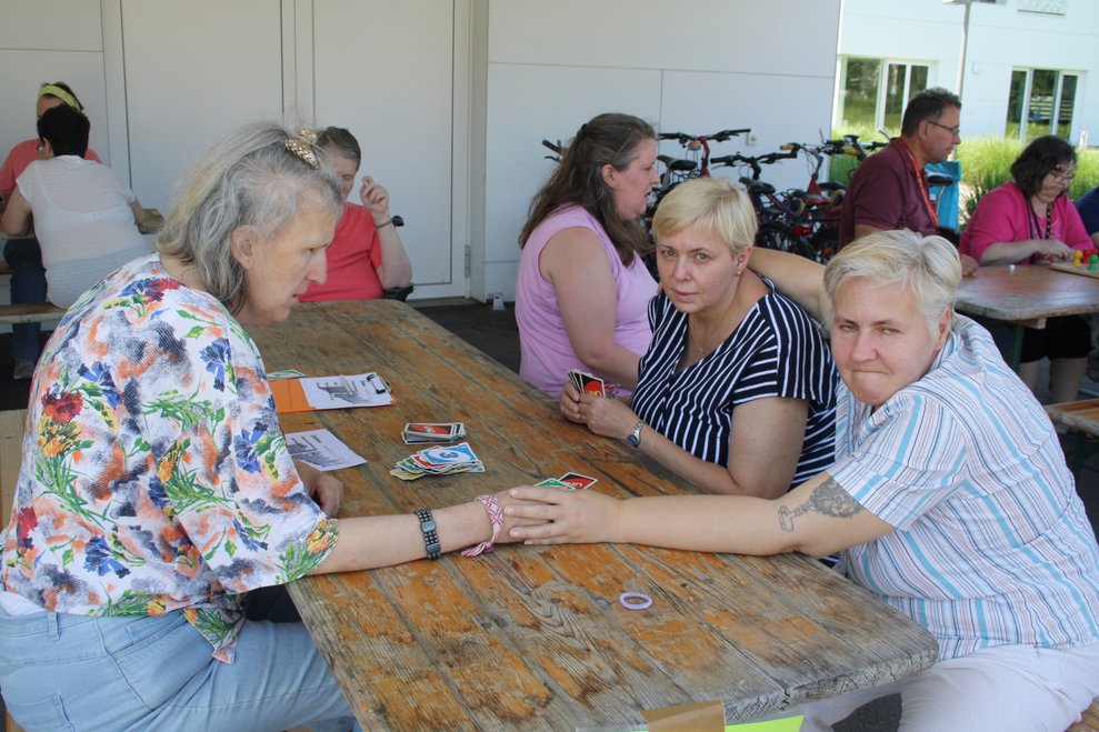 Personen sitzen bei einem Tisch und spielen