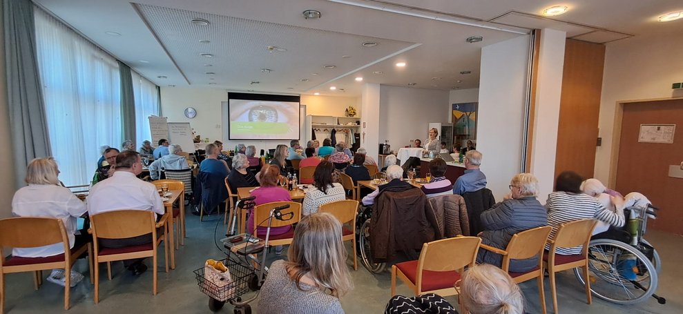 Auf Leinwand wird Text und ein Foto vom Auge gezeigt.