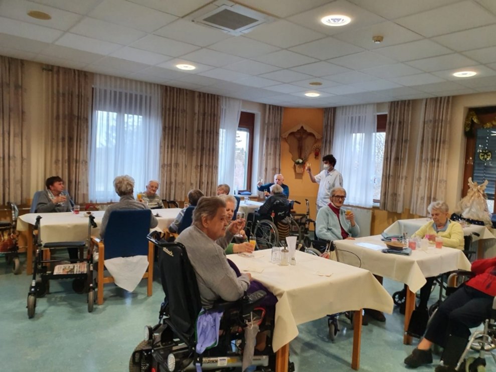 BewohnerInnen sitzen beim Tisch.