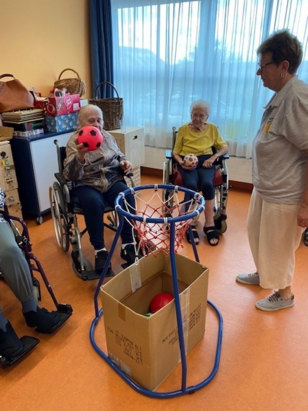 Bewohnerin schmeißt einen Ball in einen Korb