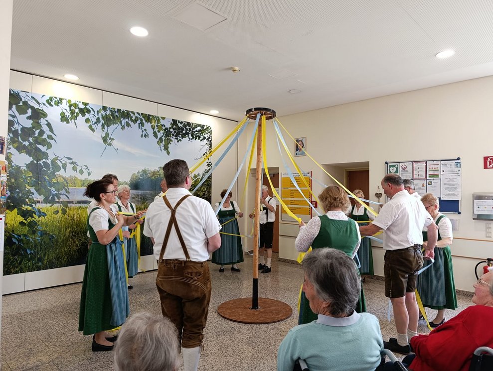 MitgliederInnen der Volkstanzgruppe Rosenburg/Mold halten die Bänder von der Stange.