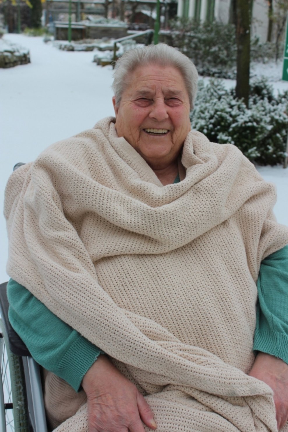 Eine Bewohnerin ist draußen beim Schnee.