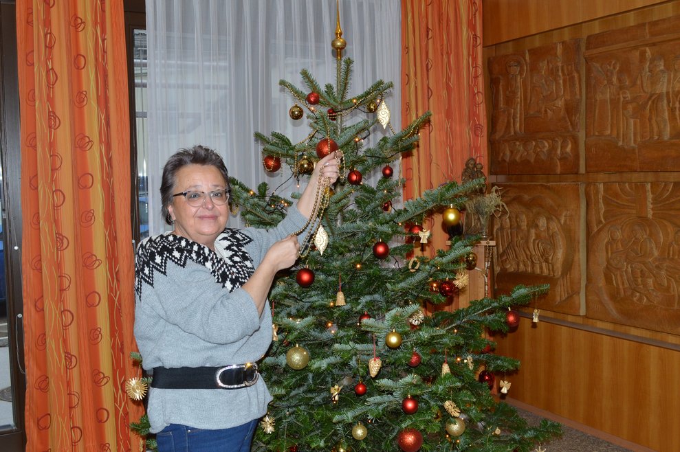 Eine Frau schmückt den Christbaum.
