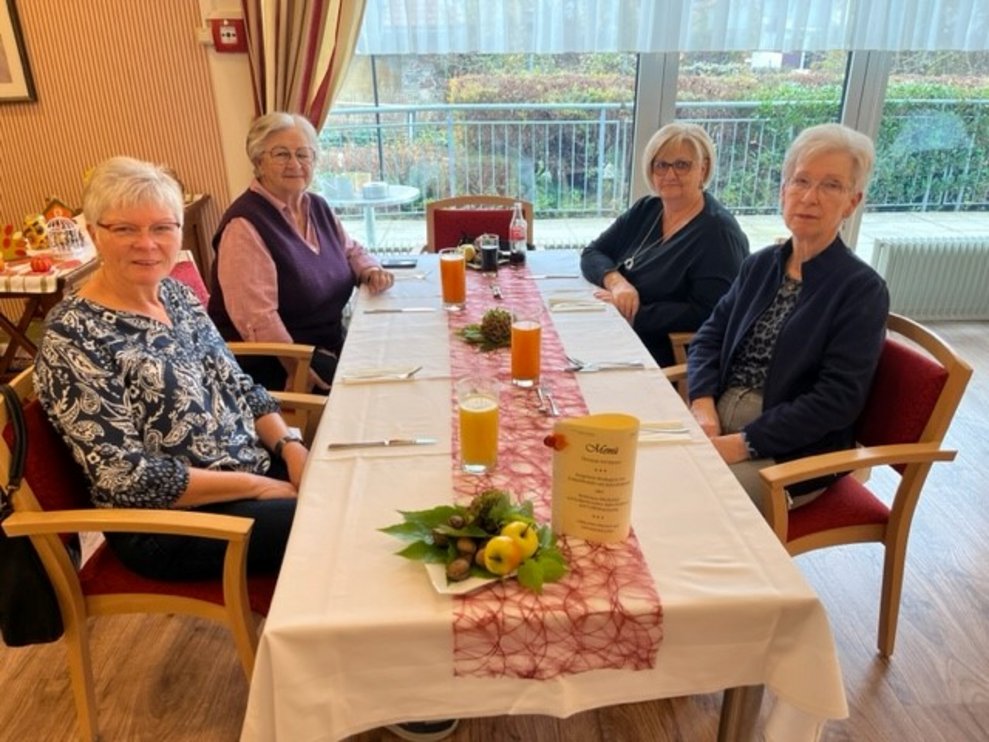 Vier Damen bei Tisch.