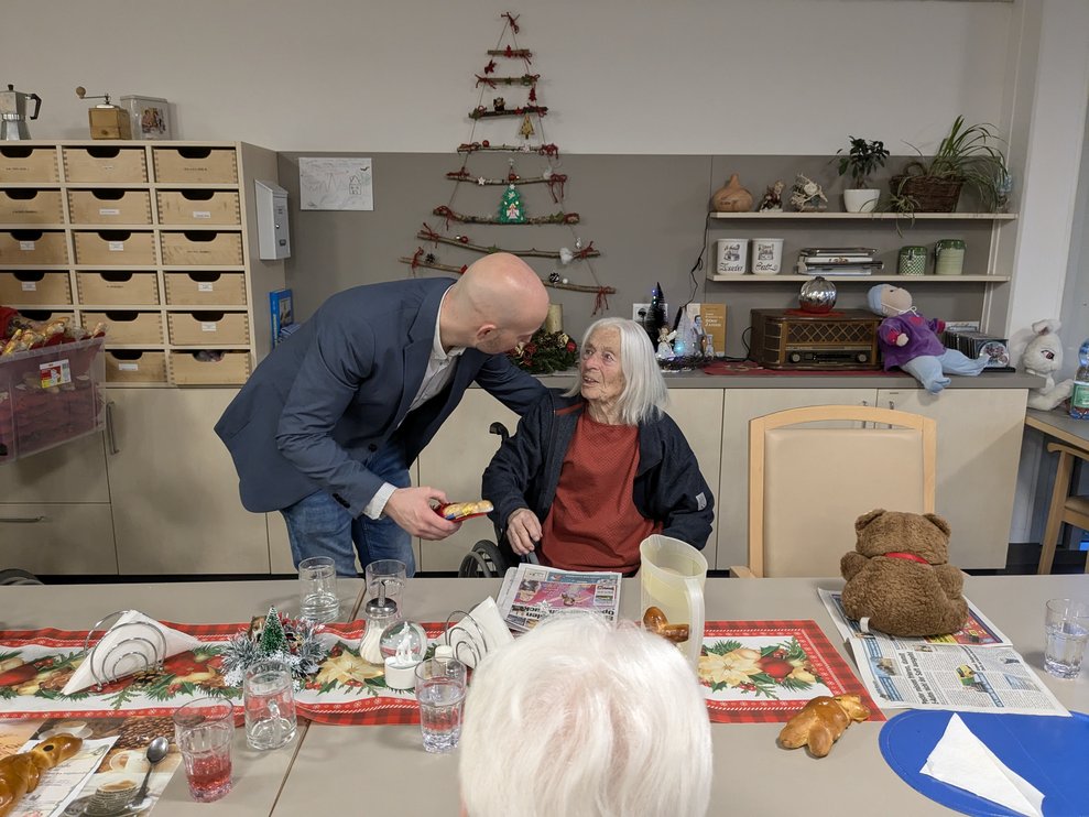 Herr Bürgermeister überreicht einer Dame das Geschenk.