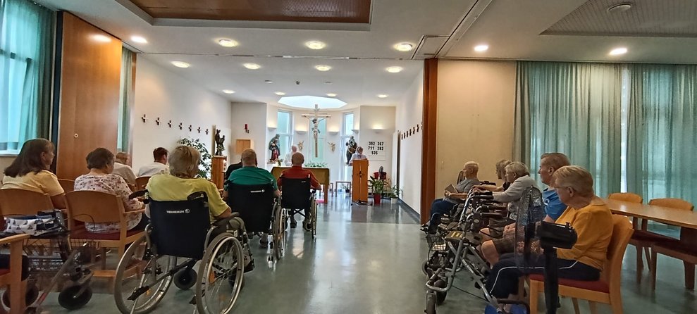 Sitzende Personen in der Hauskapelle.