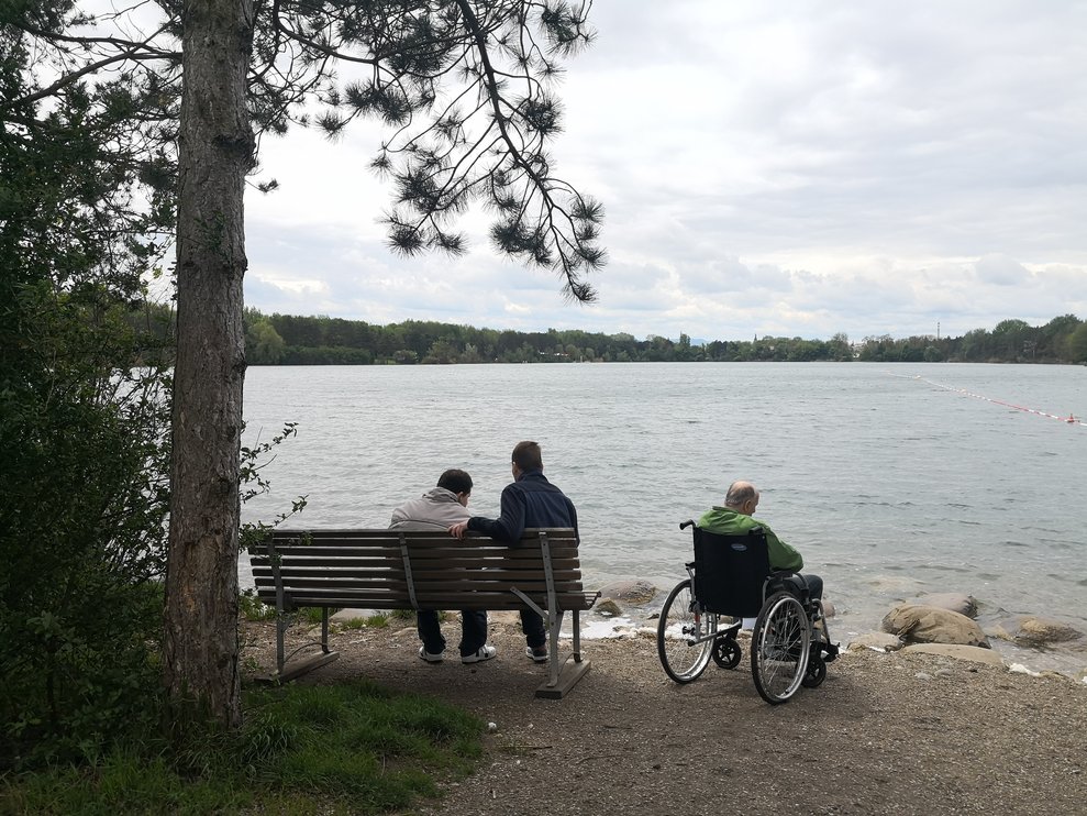 Personen stehen bei einem See