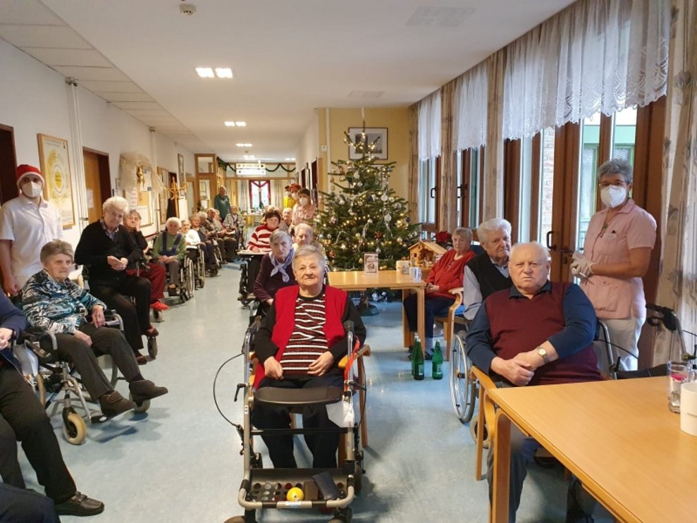 BewohnerInnen sitzen bei Tischen.