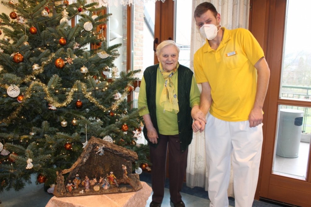 Eine Bewohnerin und ein Betreuer beim Christbaum.