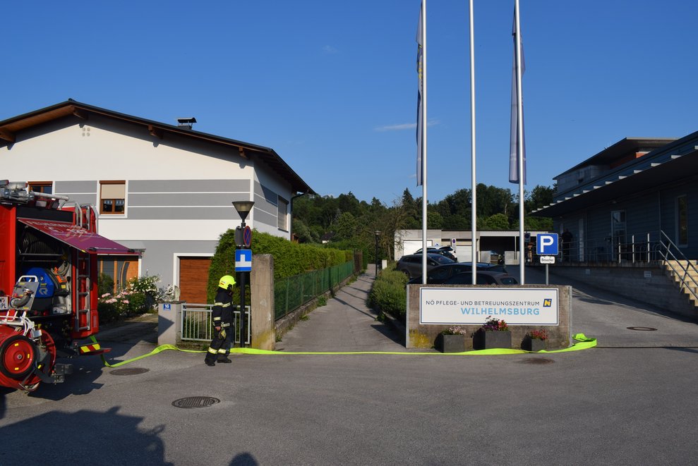 Ein Feuerwehrmann mit Auto und Schlauch vom PBZ.