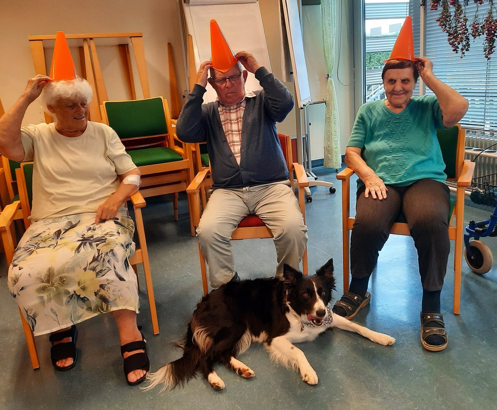 3 Personen mit Hut und ein Hund.