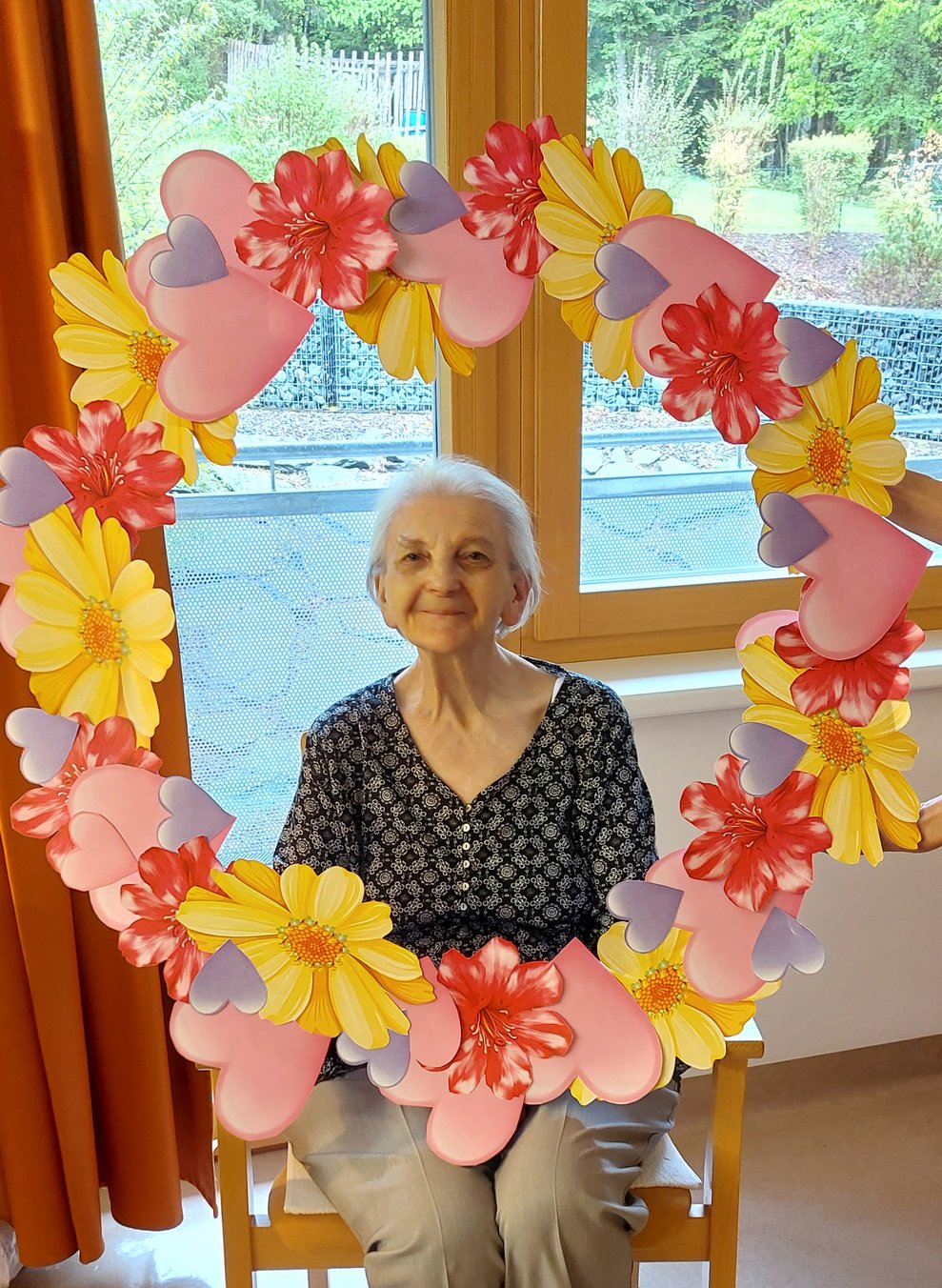 Bewohnerin mit Blumenkranz
