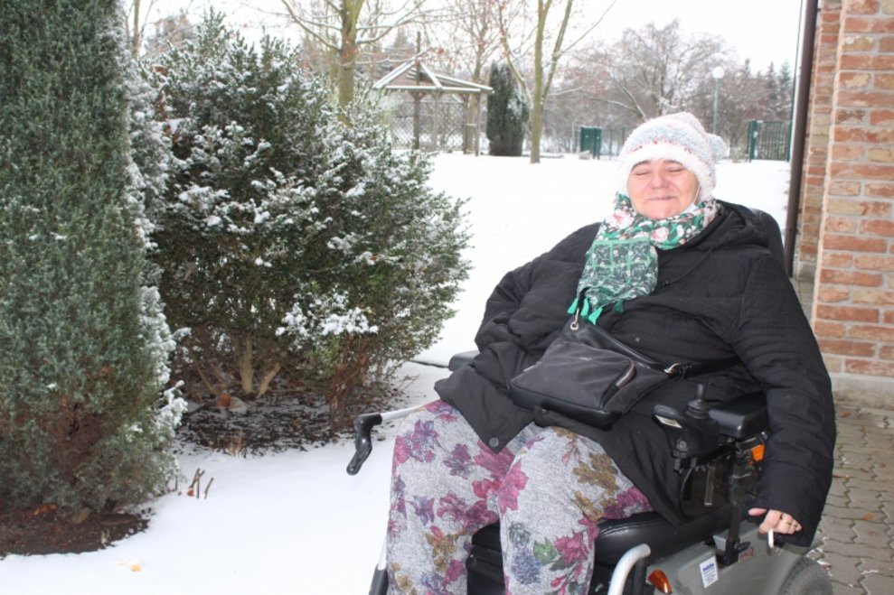 Eine Bewohnerin sitzt beim Schnee.