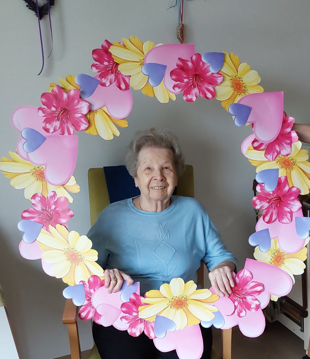 Bewohnerin mit Blumenkranz