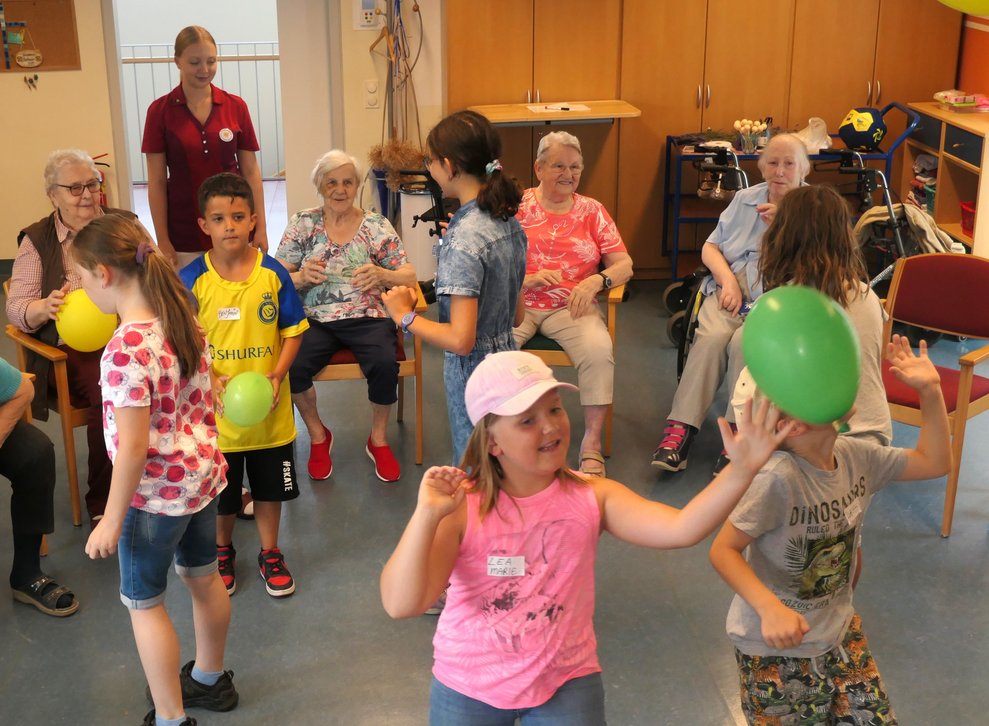 Kinder spielen mit Luftballons.