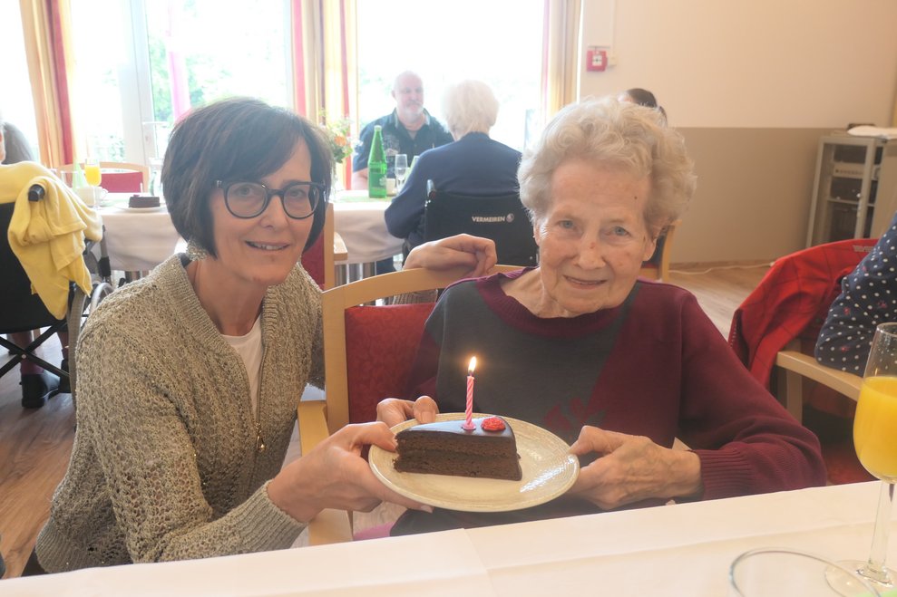 Frau Dir. Bayerl übergibt ein Stück Torte an eine Dame.