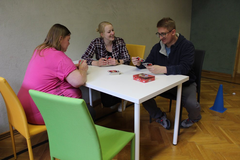 Drei Personen spielen UNO