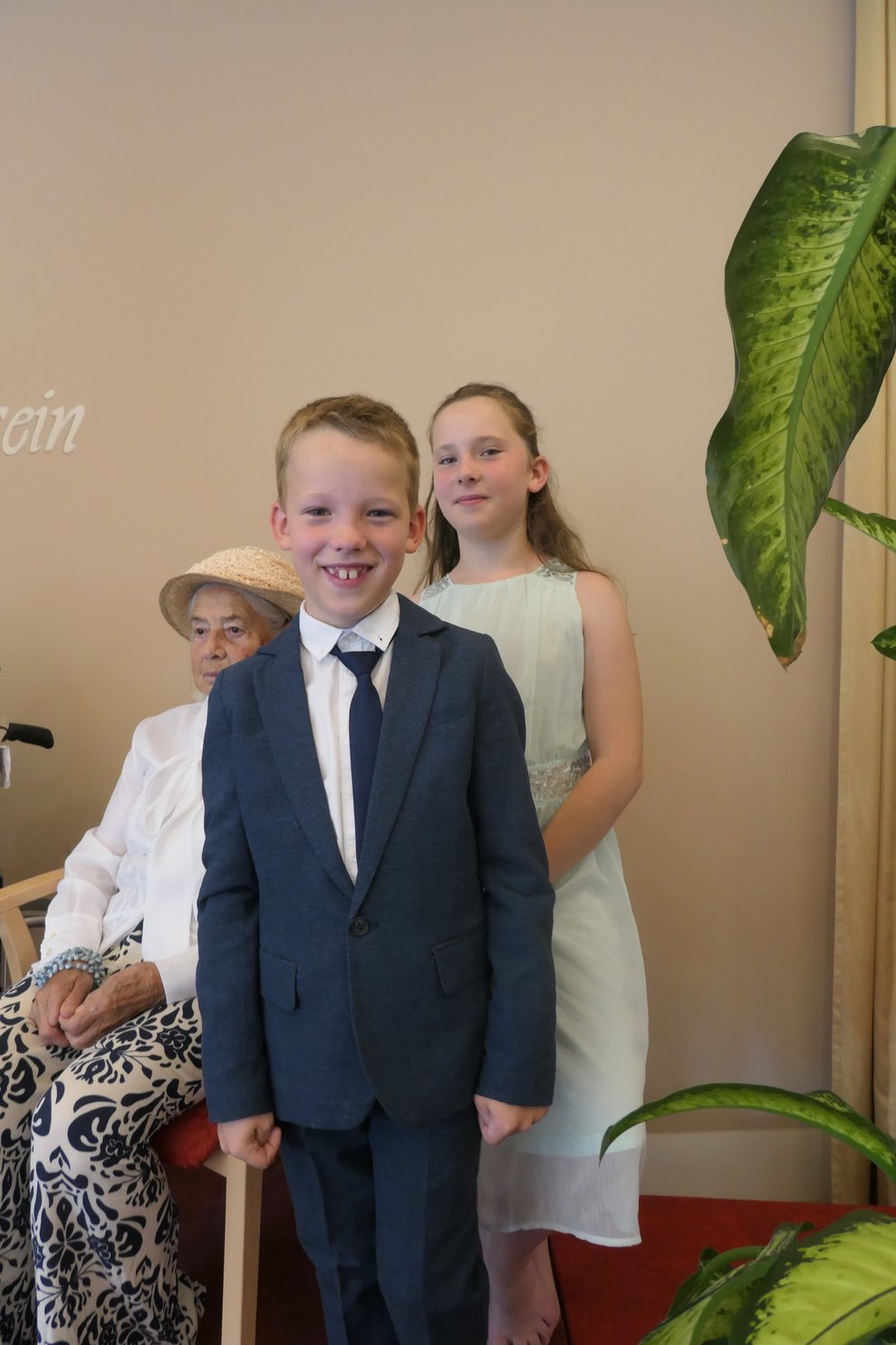 Ein Bub im Anzug und ein Mädchen im schicken weißen Kleid.