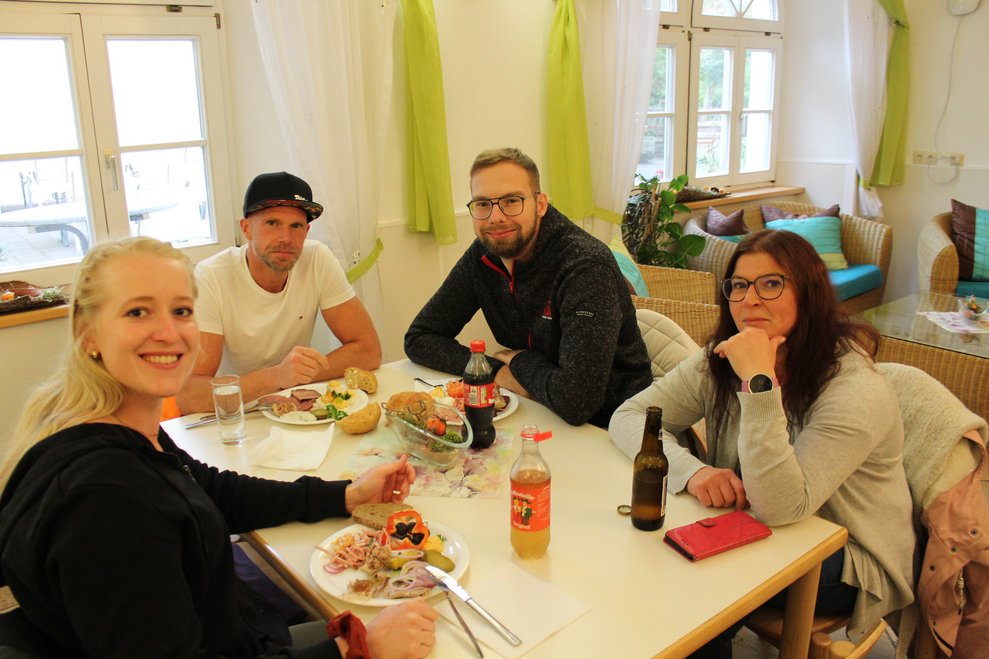 Vier Personen sitzen an einem Tisch