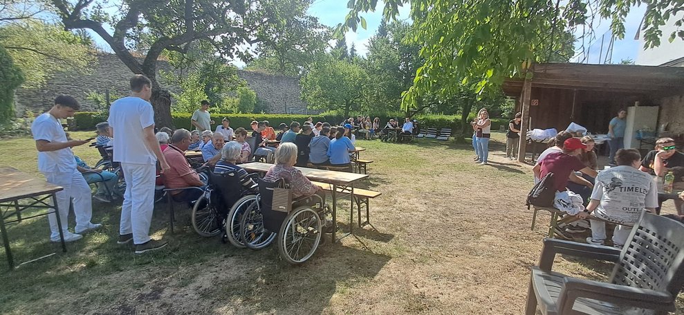 BewohnerInnen im Rollstuhl. Personen stehen.