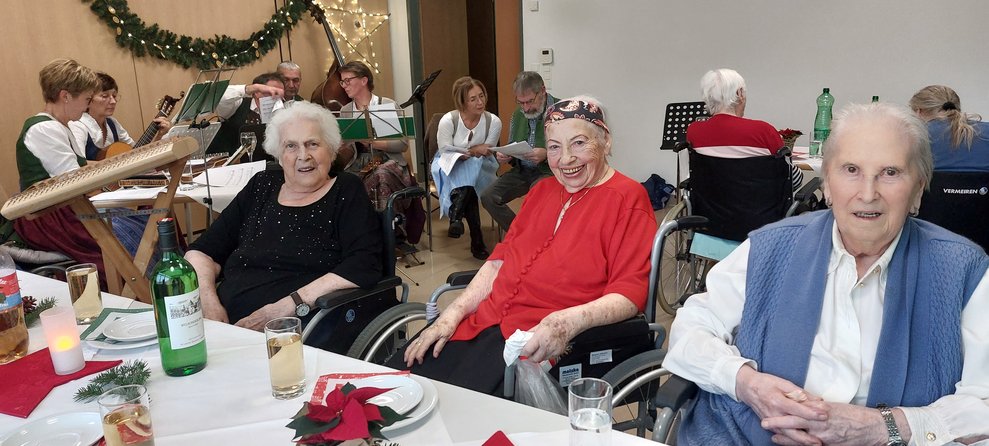 Bewohnerinnen und Bewohner sitzen an der Tafel