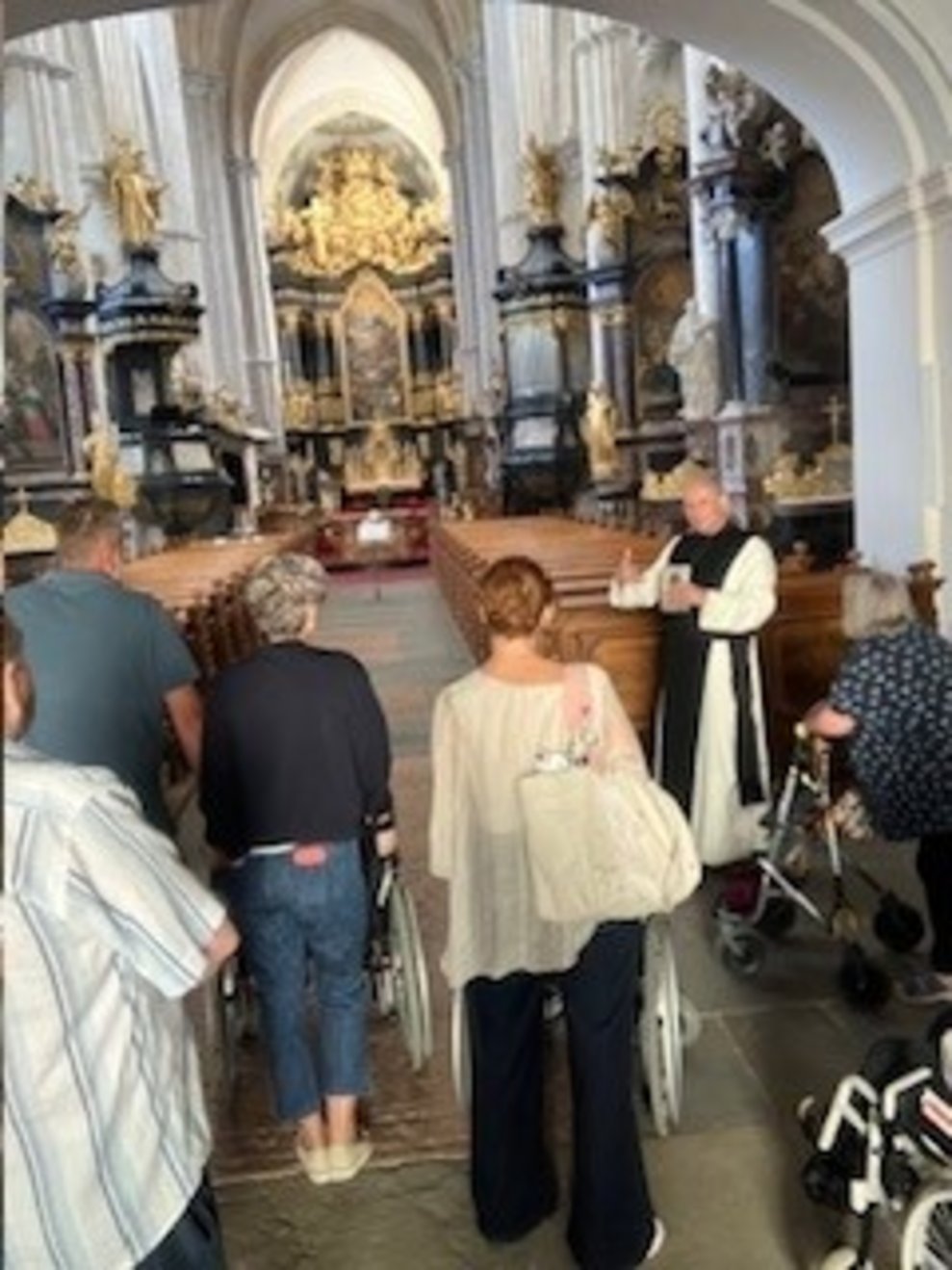 Dechant Pirngruber steht mit den Bewohnern am Eingang und führt die Kirche vor 