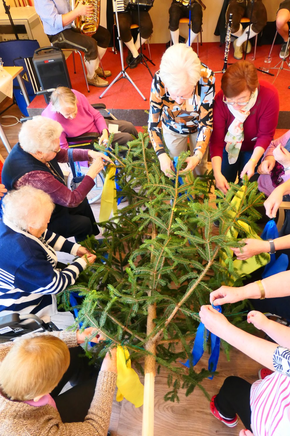 Ein paar Personen schmücken den Baum.