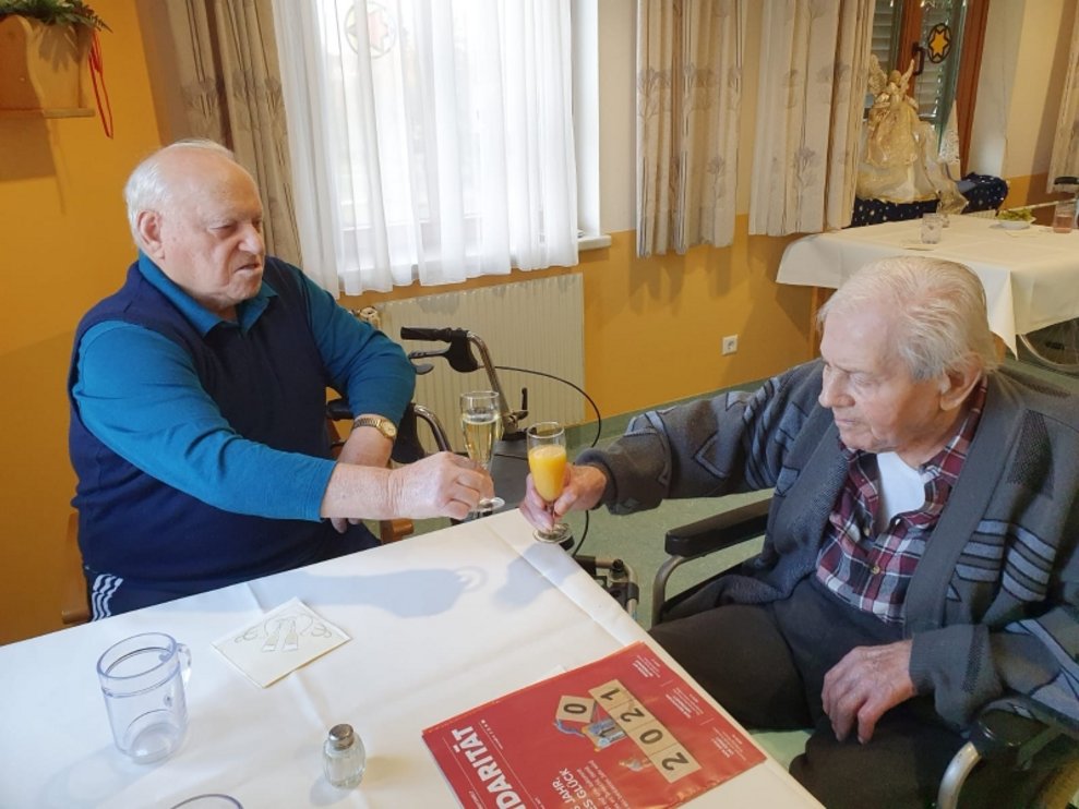 Zwei Bewohner stoßen an.