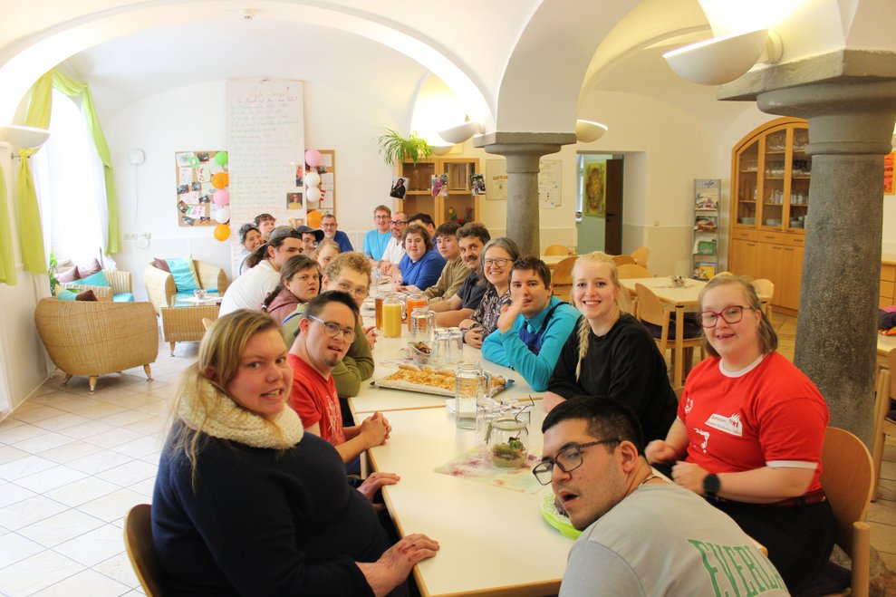 Eine Gruppe Personen sitzt an einer langen Tafel