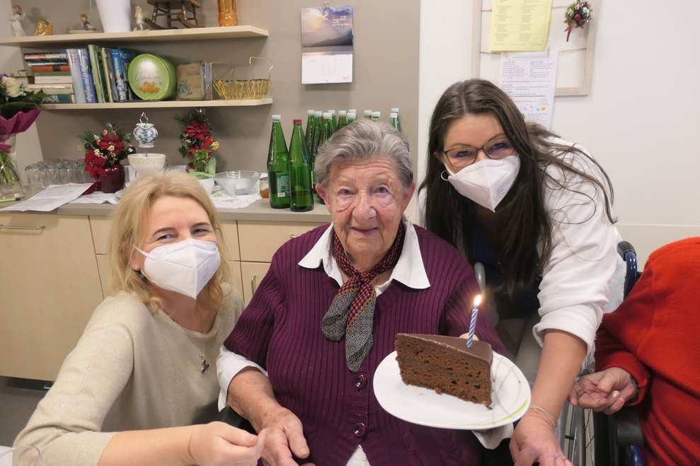 Drei Damen mit einem Stück Torte.