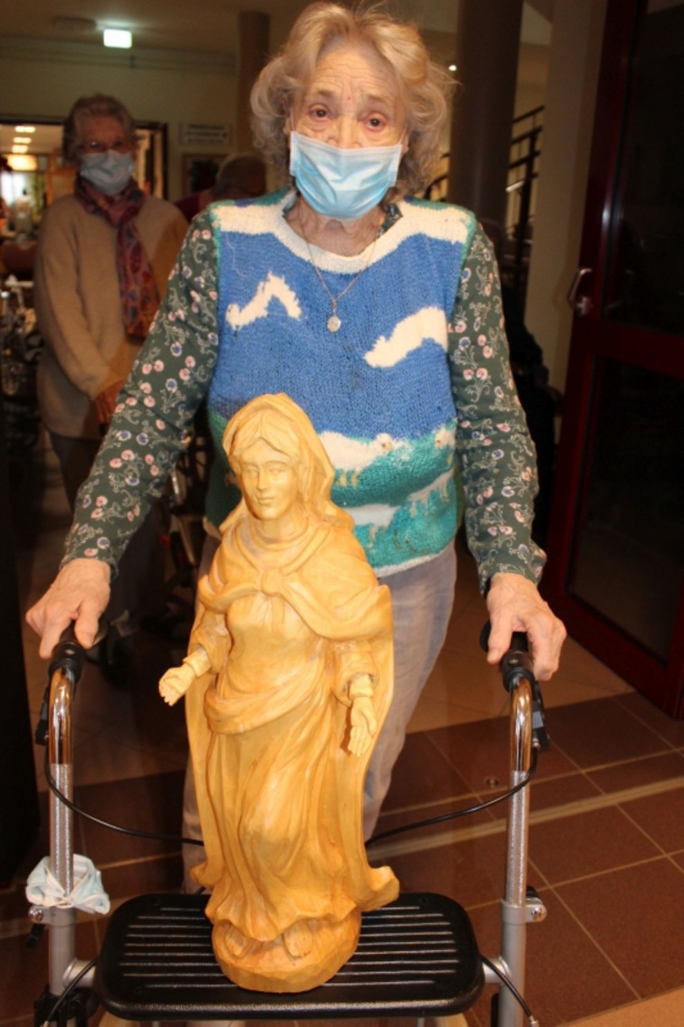 Eine Bewohnerin mit einer Mutter-Gottes-Figur.