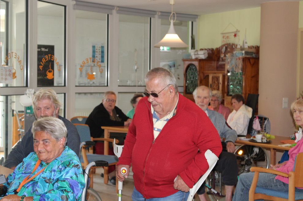 Bewohner geht mit Krücken an Dame vorbei