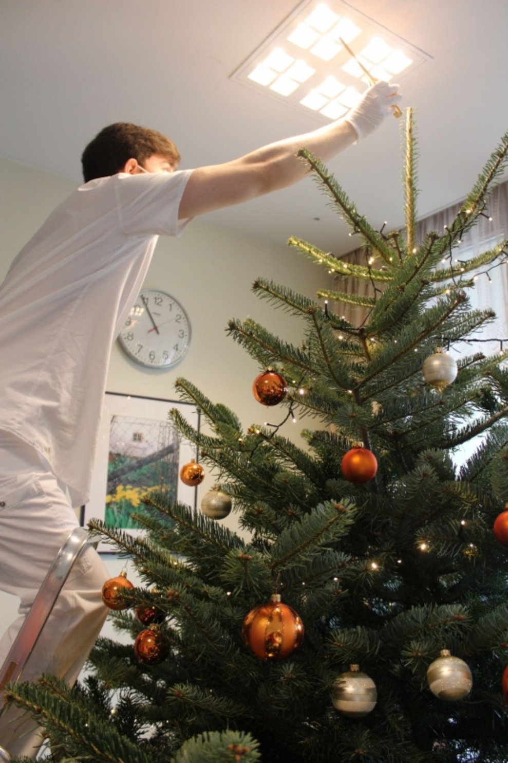 Der Zivildiener schmückt den Baum.
