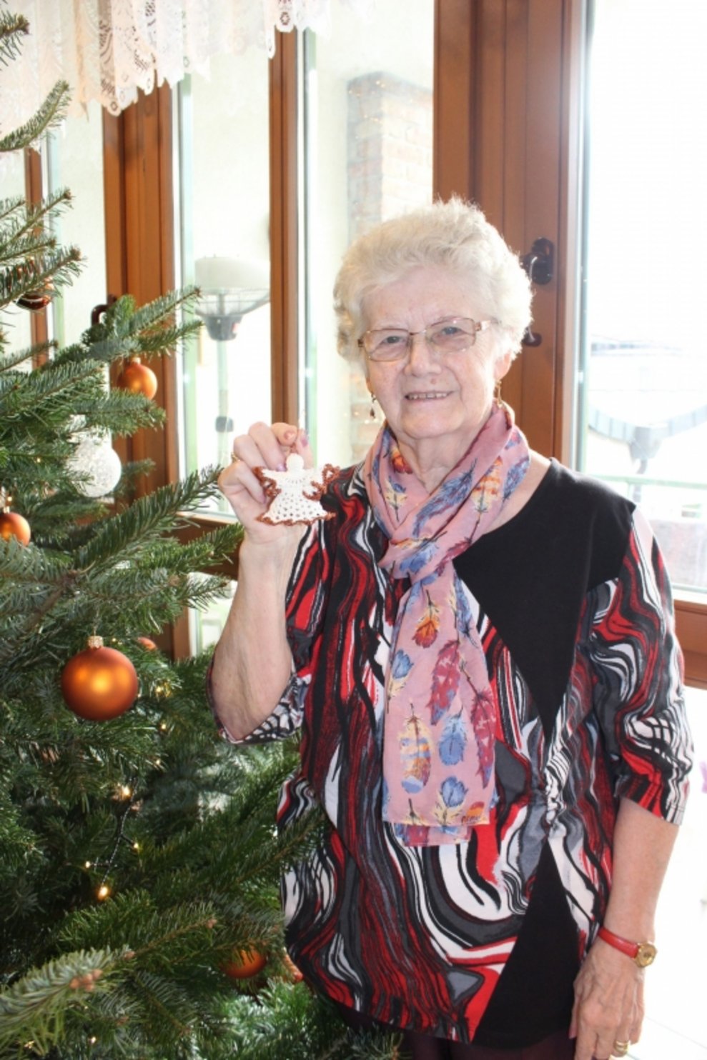 Eine Bewohnerin steht beim Christbaum.