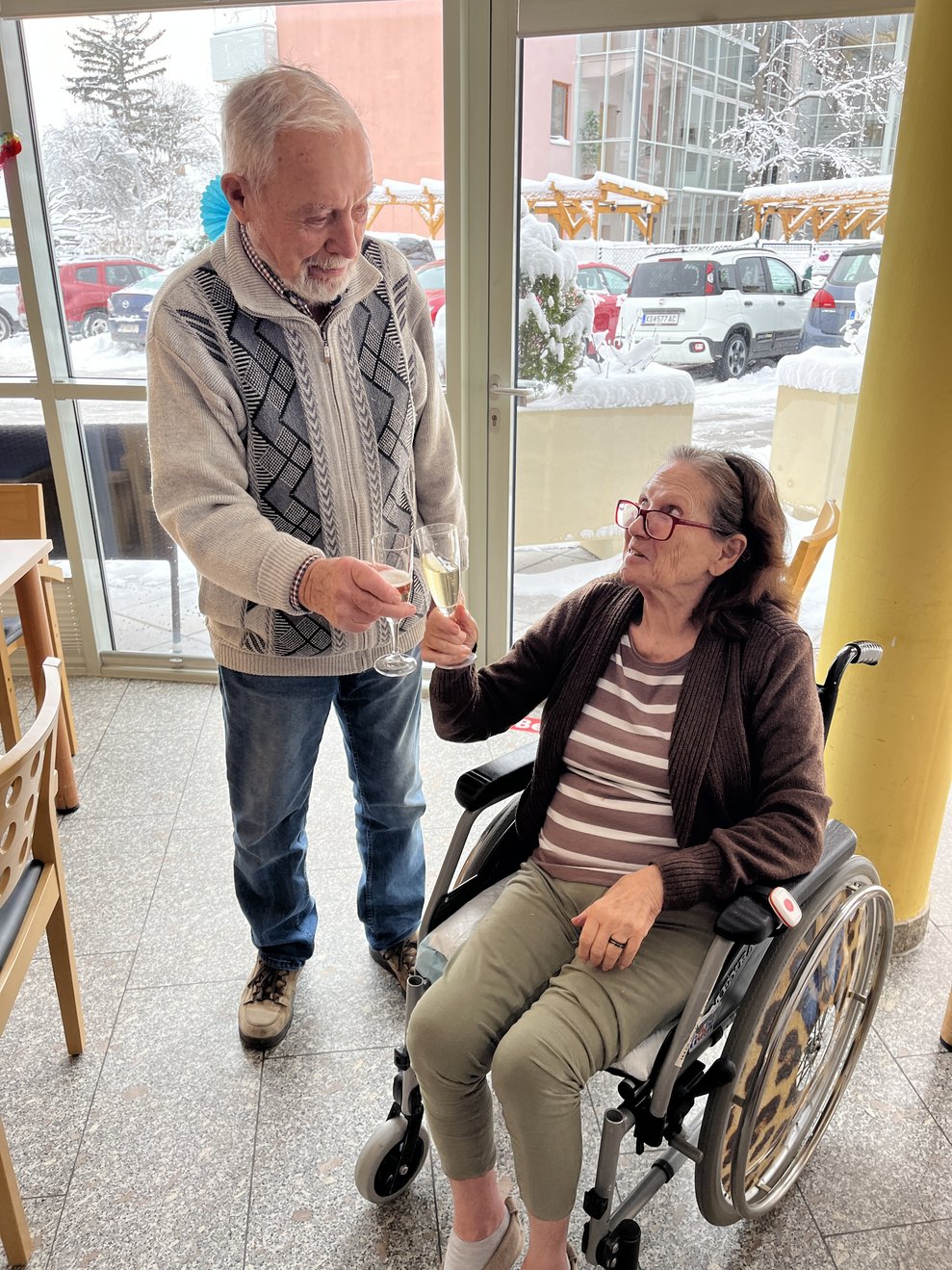 Zwei Personen stoßen mit Sekt an.