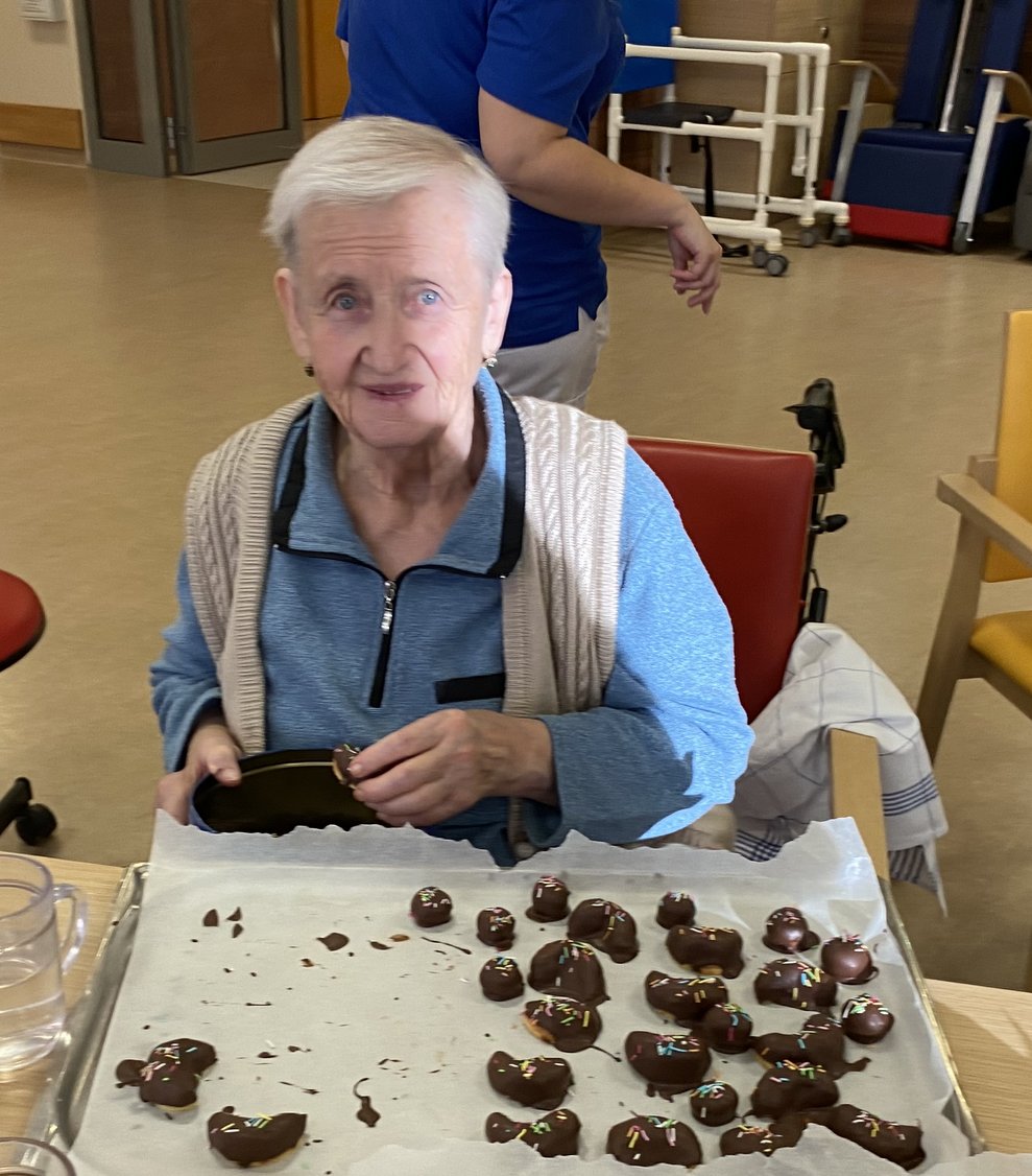 Frau Gratzl gibt die fertigen Punschkipferl in die Dose.