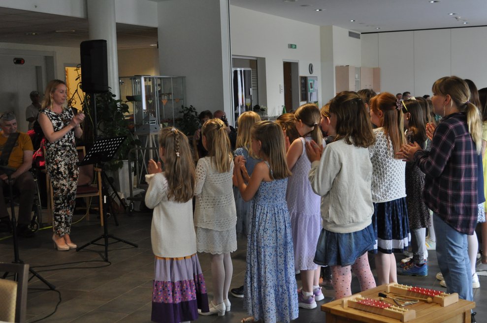 einige Kinder singen und klatschen